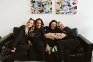 Picture of women sitting close together, hugging and smiling